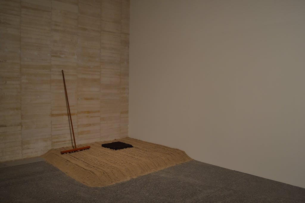Gina Pane
Stripe Rake, 1969
Sable, humus, un râteau de bois
Piece made of 2m2 of sand, 1m2 of earth, a wooden rake made by me, which was left out for the public so that they could activate the space occupied by the sand and earth. 
Stripe Rake, 1969. Turin
17 x 200 x 200 cm - © &copy; ADAGP Gina Pane
Photo. MUSAC
Courtesy Anne Marchand and kamel mennour, Paris/London, Mennour